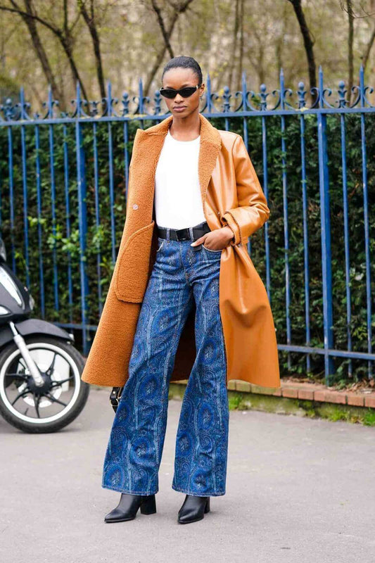 Girl wearing boho pants standing next to a scooter